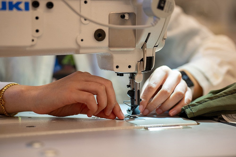 hands on material in sewing machine