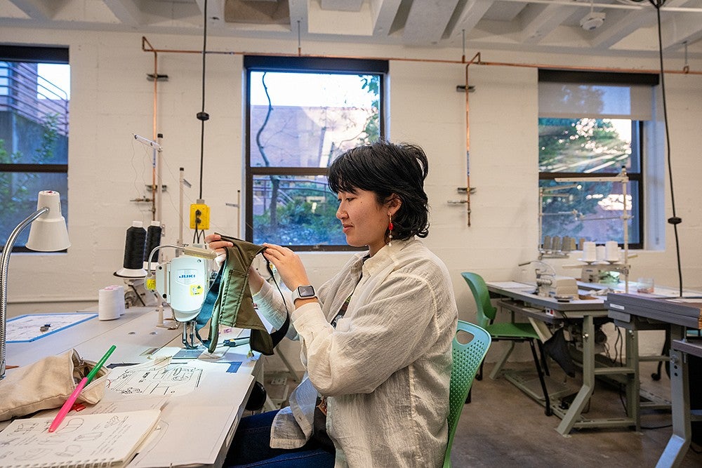 student in studio at sewing machine