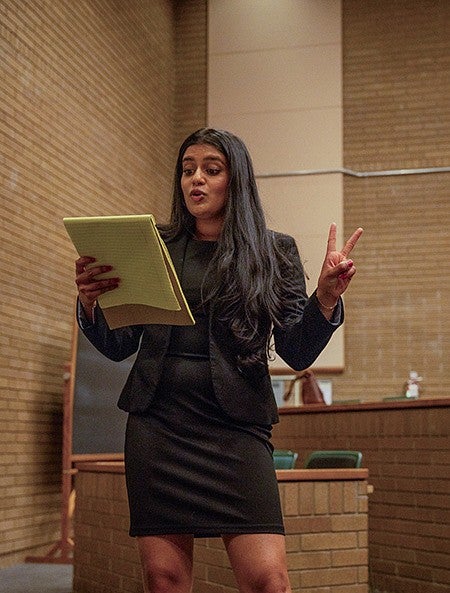 student arguing for mock trial holding legal pad