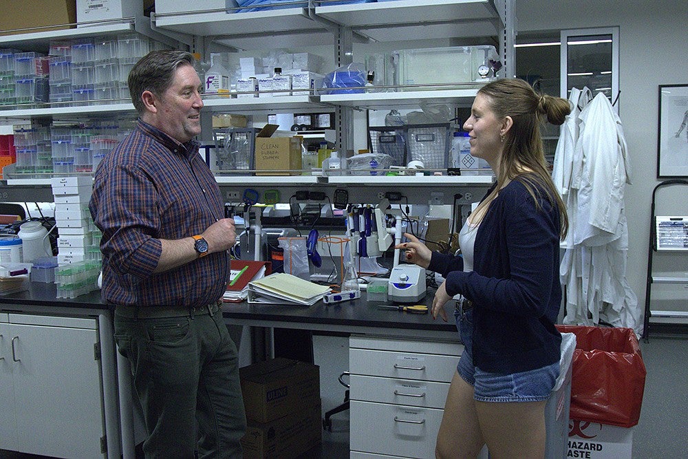 student talking to professor in lab