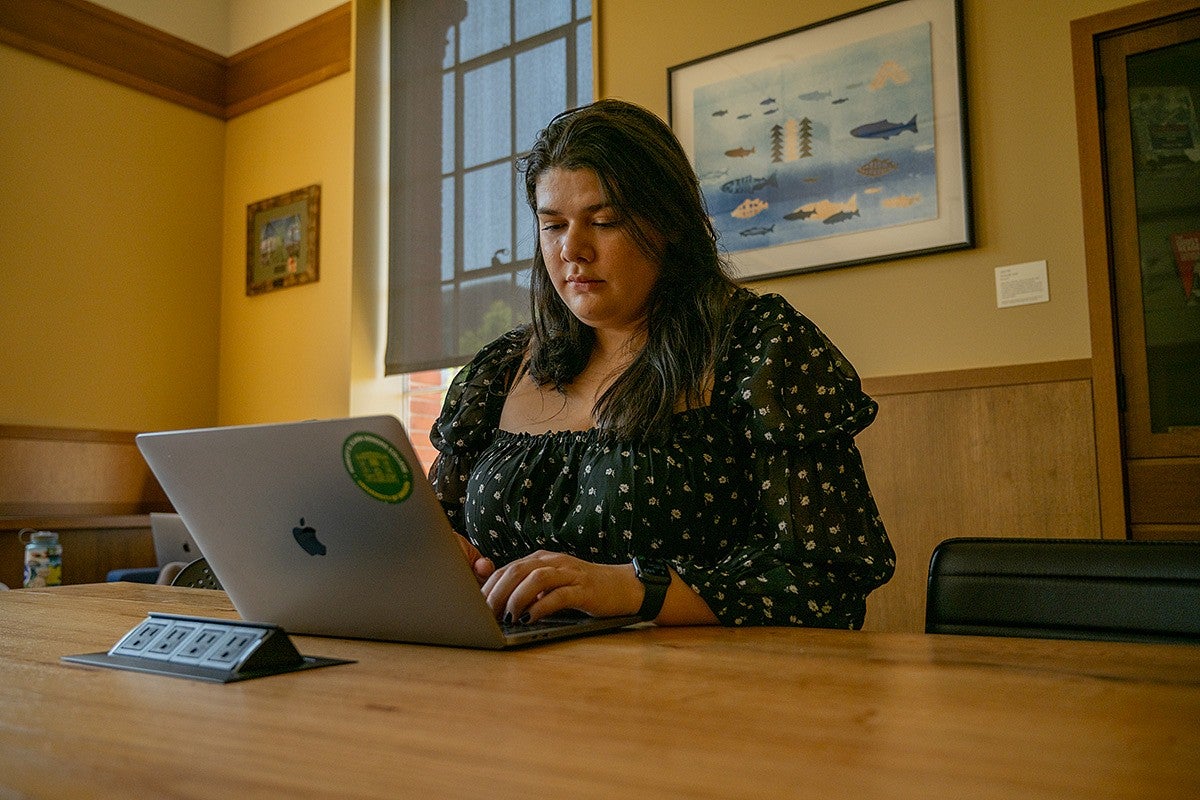 student on laptop in chapman library