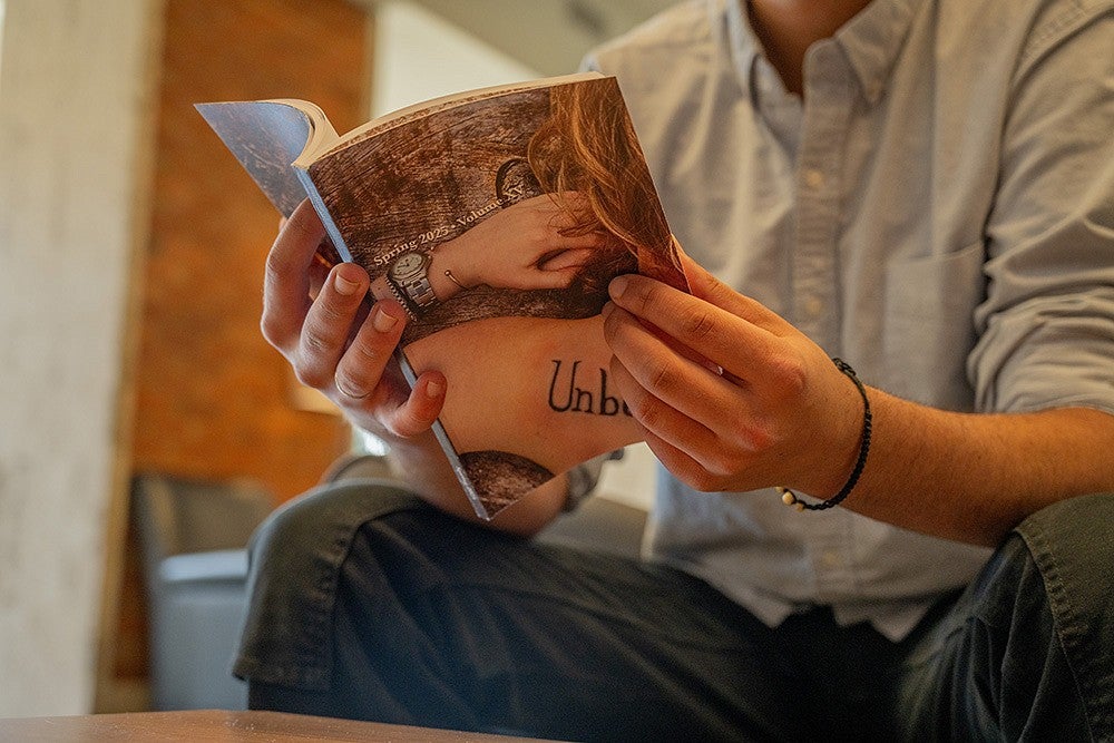 hands holding copy of unbound creative writing journal