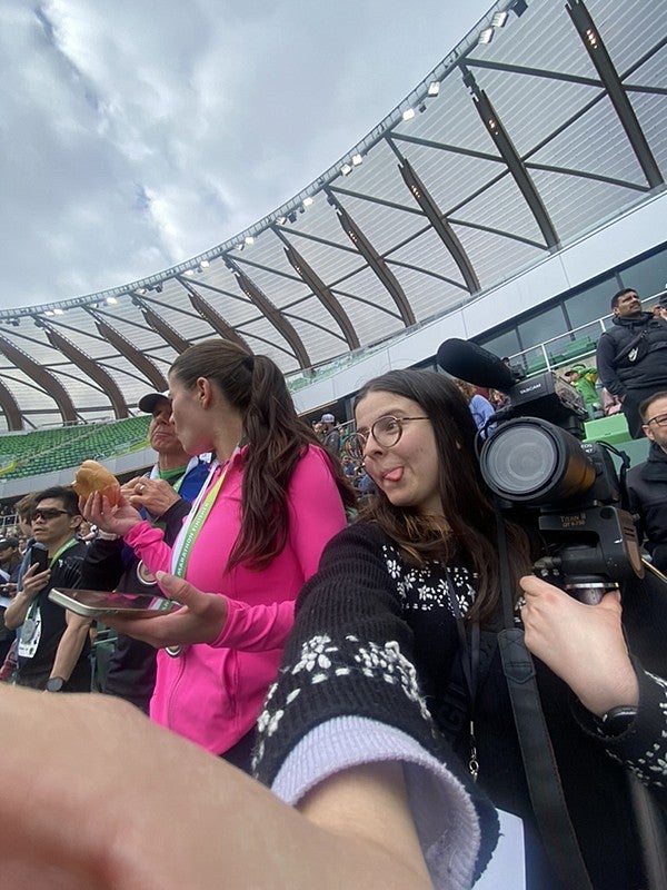 person holding camera and taking selfie with phone in hayward field stands