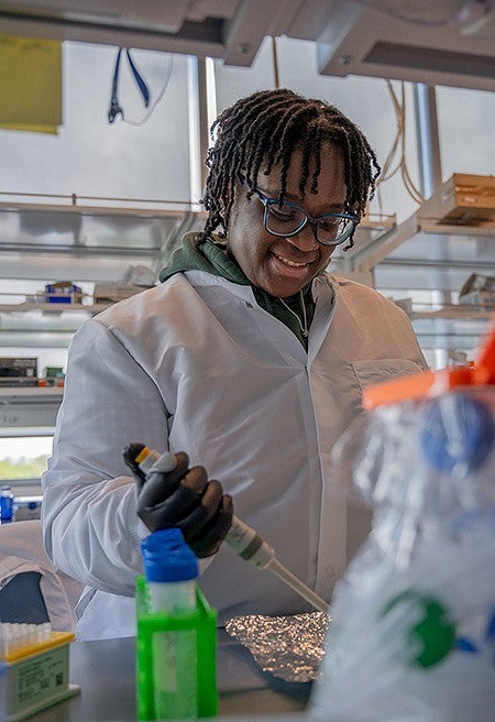 student at lab bench pipetting