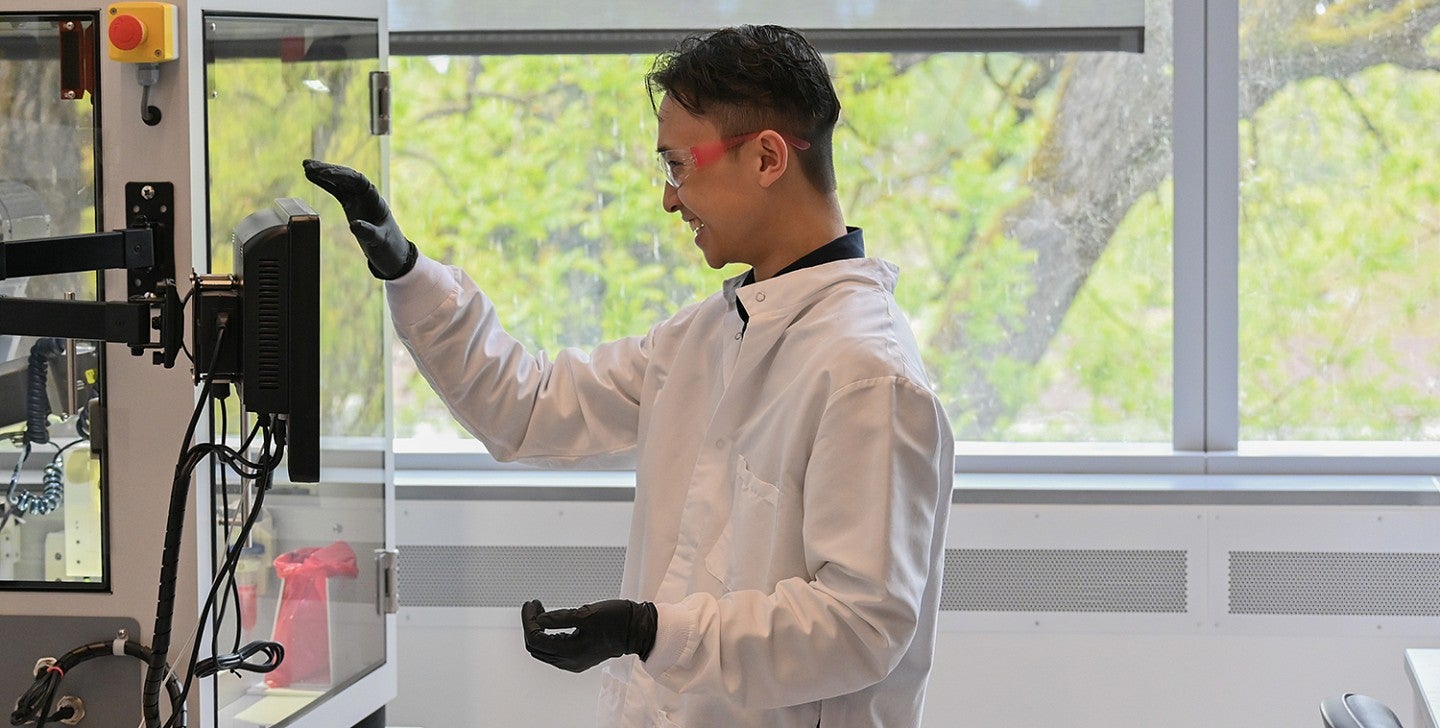 student in a campus lab working with equipment