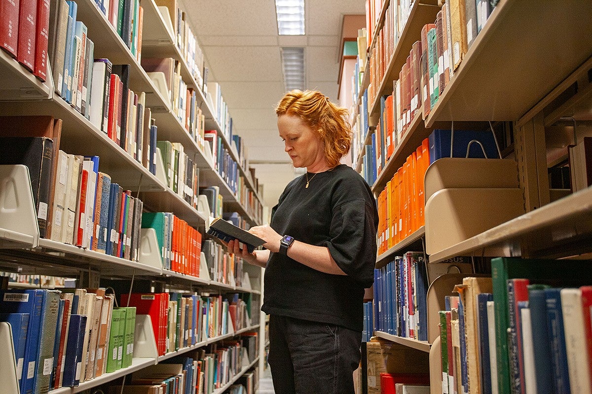 lizzy lerud browsing books in the Knight Library stacks