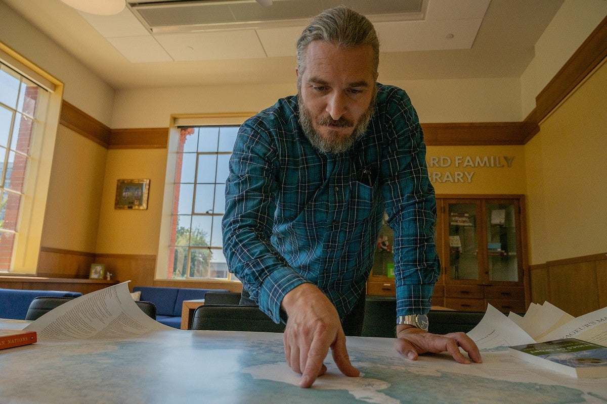 marcel brousseau pointing at a map on a table in Chapman library