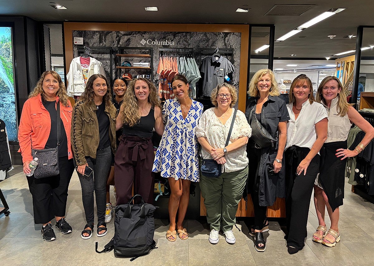 group of women standing in front of Columbia sportswear department store display