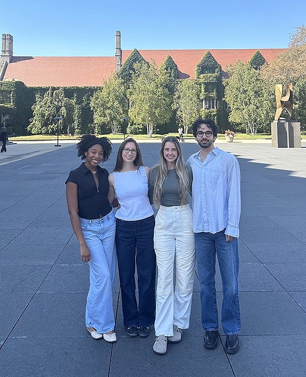 group of four friends posing in university courtyard