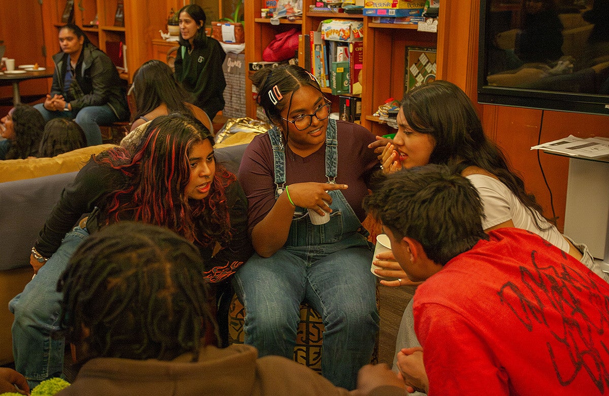 students huddled together in a meeting in Mills International Center