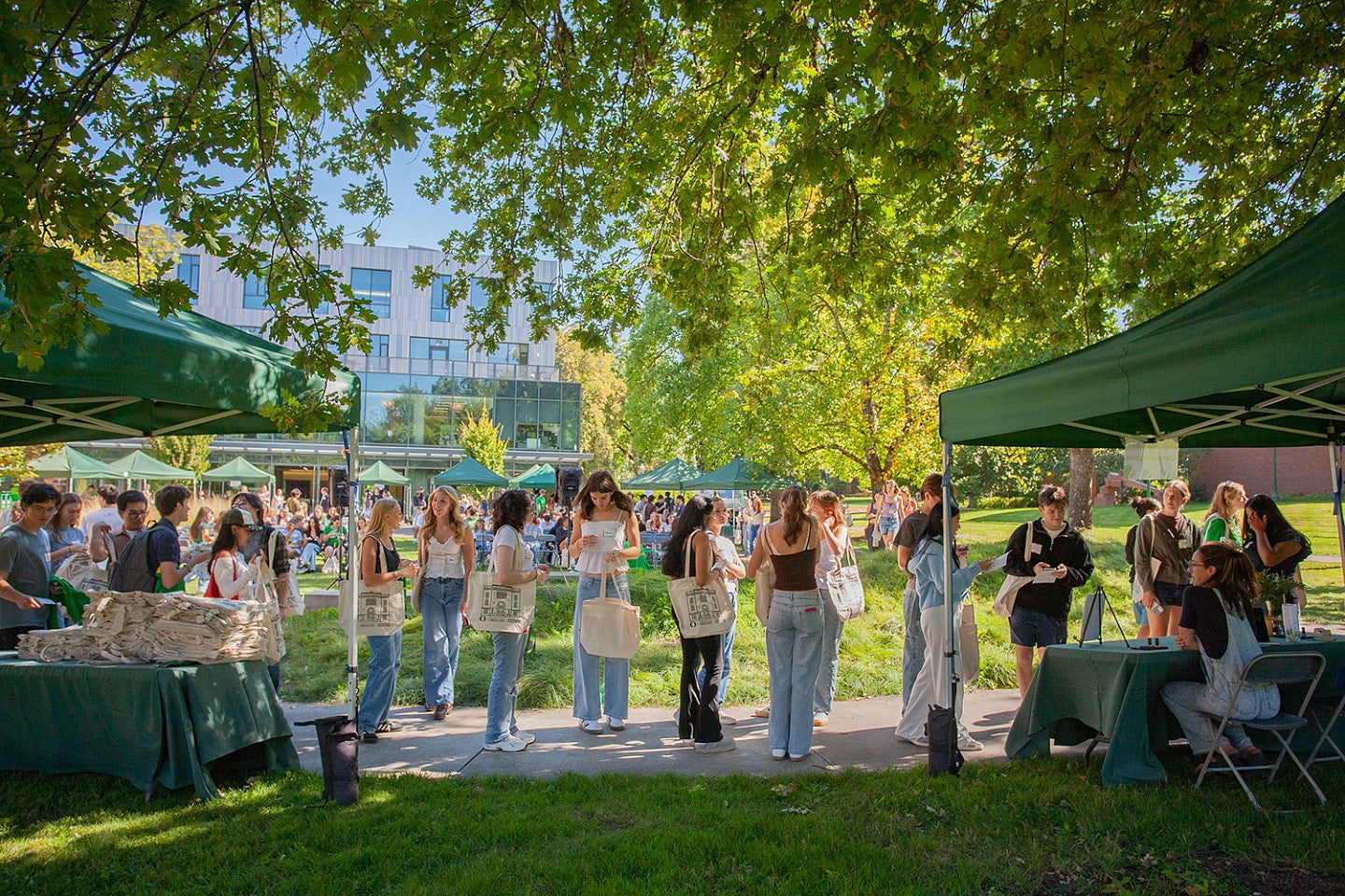 new students at a welcome event on McCaslin lawn with pop-up tents under the trees