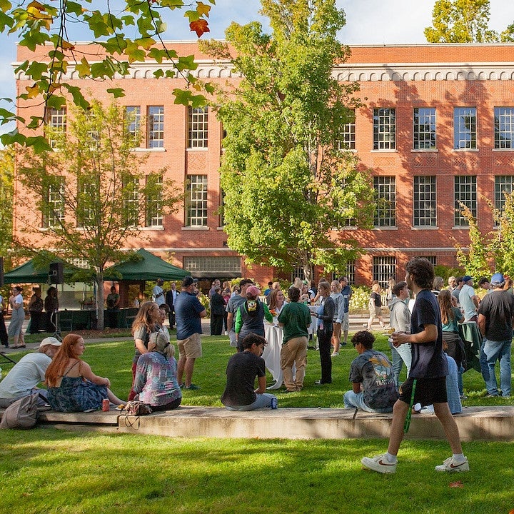 people gathered at an event on McCaslin Lawn with Chapman Hall in background