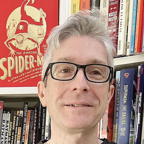 ben saunders in front of shelves of books and comics