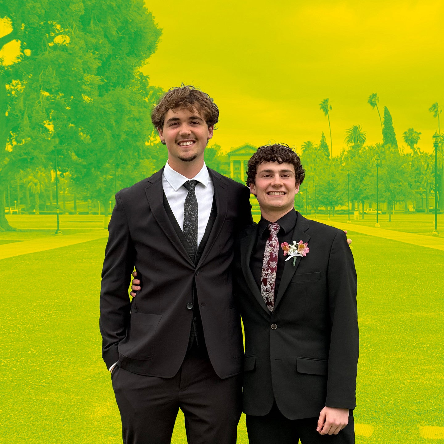 twin brothers in formal suits standing on a manicured lawn with the background in yellow and green duotone