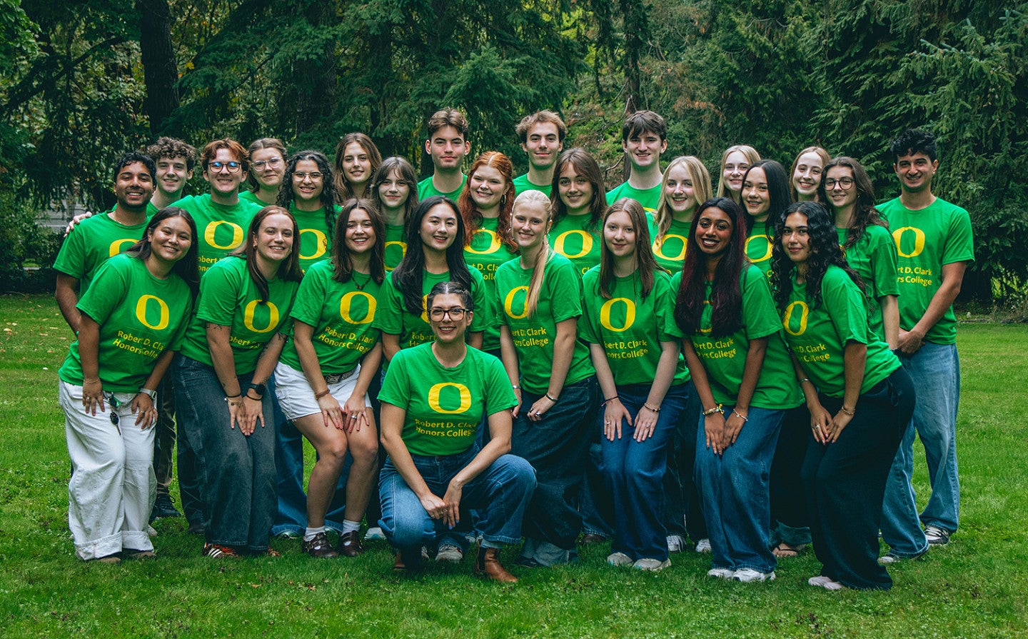 group of chc peer mentors in green tshirts posing on campus green space