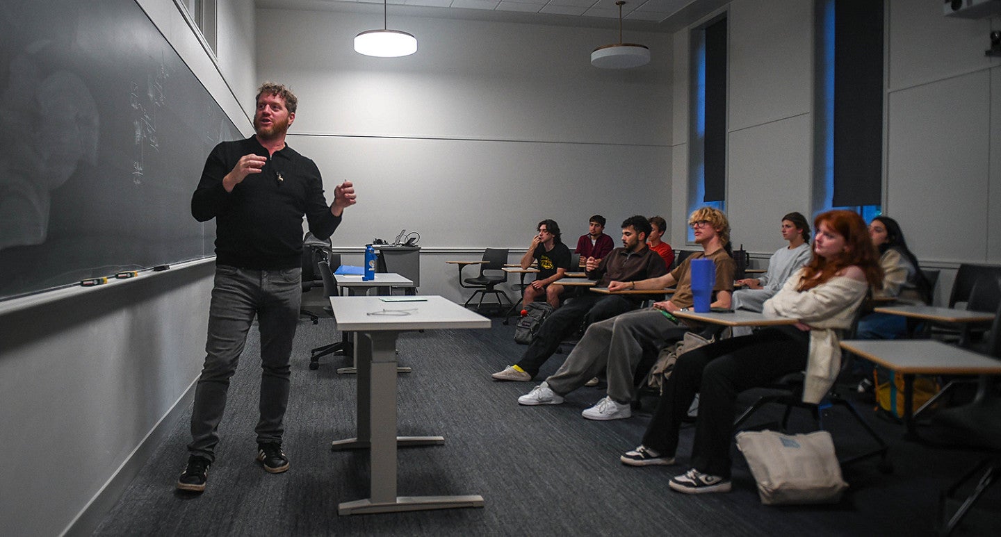 tobin johnston teaching at a chalkboard in front of students in classroom