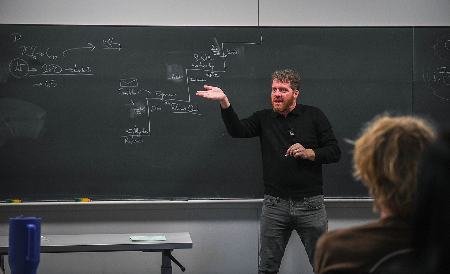 Tobin Johnston teaching a class in front of a chalkboard