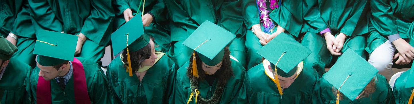 Birdseye view of graduates in green gowns and mortarboard caps.