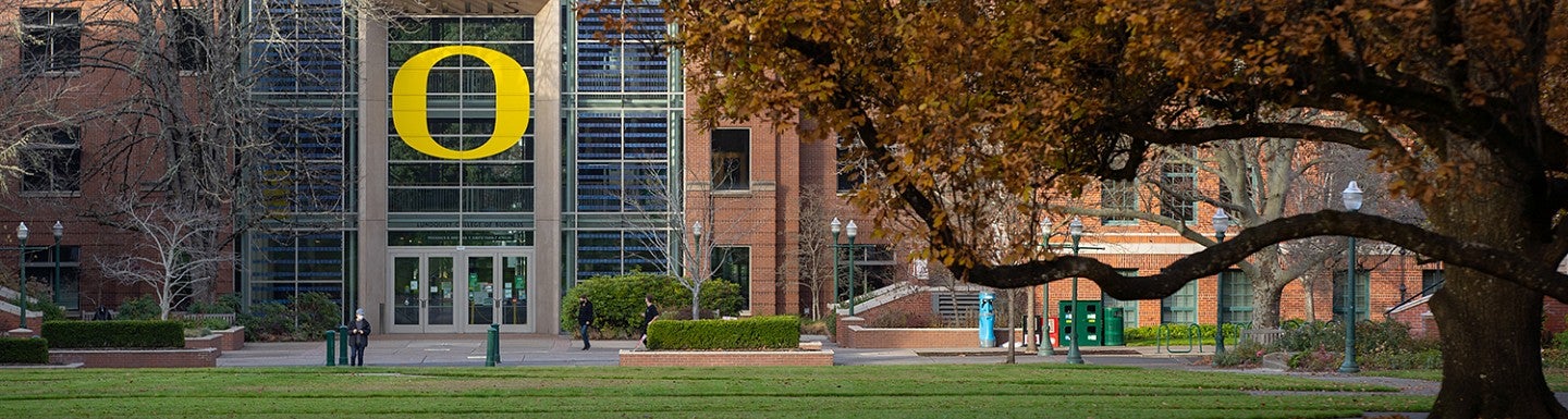 view of the lillis business complex from the memorial quad with large beech tree in foreground
