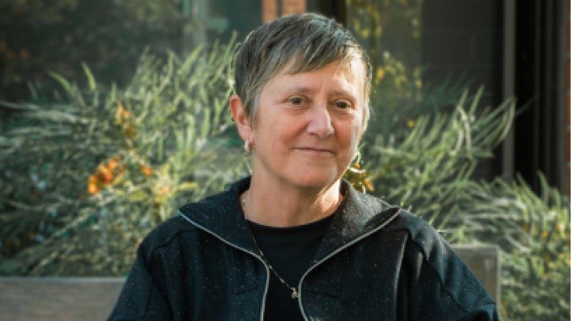 Carol Stabile sitting outside on a bench 