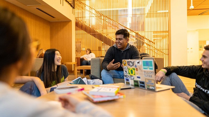students laughing around a table in a study lounge