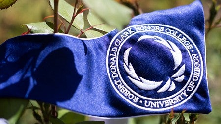 Blue pennant with white text "Robernt Donald Clark Honors College, University of Oregon"