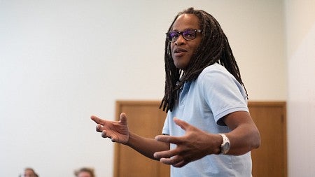 ulrick casimir gesturing while teaching at the front of a classroom