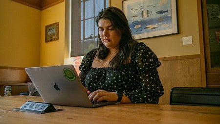student on laptop in chapman library