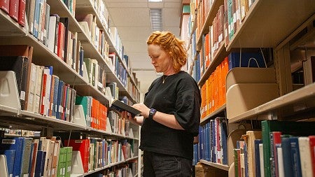 lizzy lerud browsing books in the Knight Library stacks