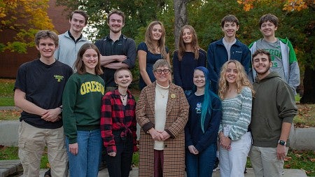carol stabile with six sets of twin CHC students posing on campus lawn