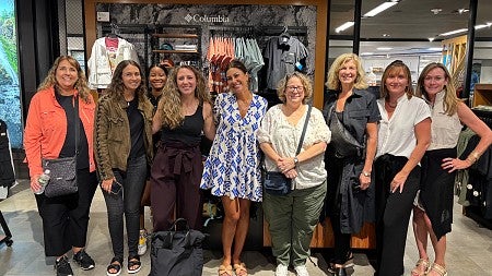 group of women standing in front of Columbia sportswear department store display