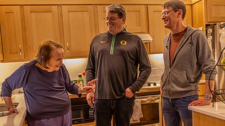 fred poust with his mother joy and brother alex in a kitchen