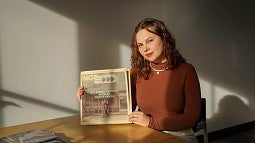 portrait of nika bartoo-smith with a front page newspaper article she wrote with the headline "Gold Rush Outpost now in Native Hands" and a family posing infront of a general store