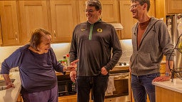 fred poust with his mother joy and brother alex in a kitchen