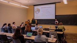 classroom of students watching two students present slides