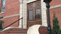 Western stone stair leading up to Chapman Hall's wooden door set in the red brick.