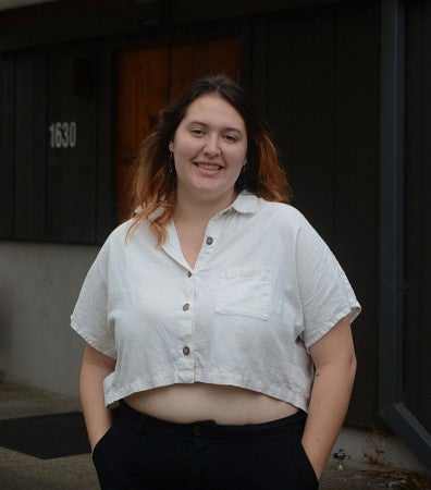 Marisol Peters standing in front of a dark building entrance cover