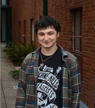Micah Primack standing in front of a brick building