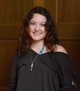 Ailah Altemus standing in front of a dark wood paneling