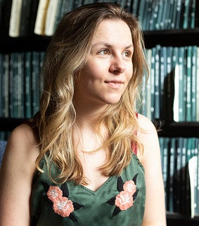 Lisa Roberts in front of a shelf of theses.