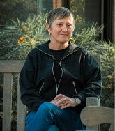 Carol Stabile sitting outside on a bench 