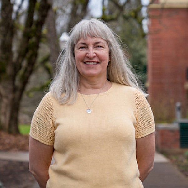 Lisa Wolverton standing outside Chapman Hall on an early spring day.