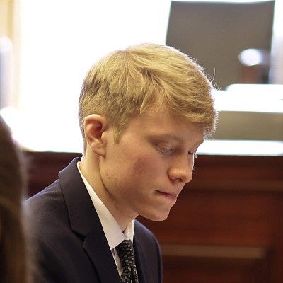 photo of ethan scott in suit, looking down and to the side