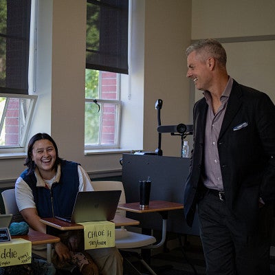 tobin hansen teaching in a classroom with students laughing at desks