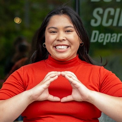 student throwing the O in front of glass with "science department" screenprinted on it