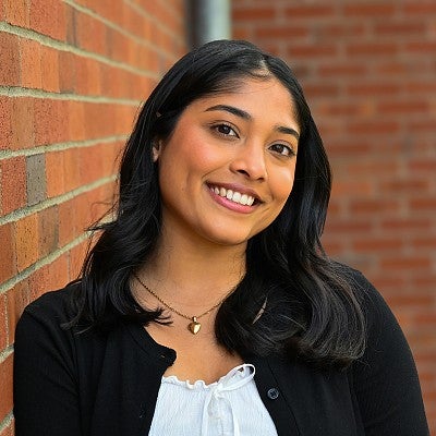 portrait of aarushi dhamdhere outdoors next to brick wall