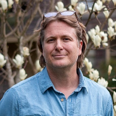 headshot of Casey Shoop with white magnolias in background