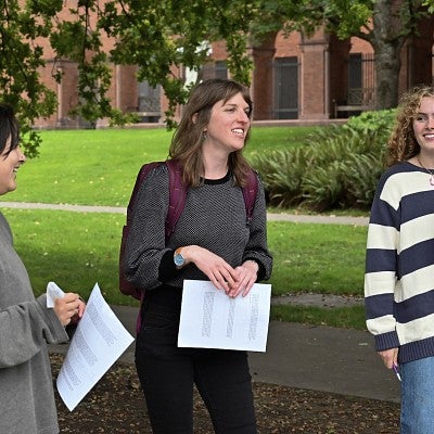 Kristen Rahilly teaching outside, standing among students