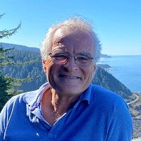 portrait of michael boehnke with forested coastline in background