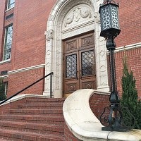Western stone stair leading up to Chapman Hall's wooden door set in the red brick.